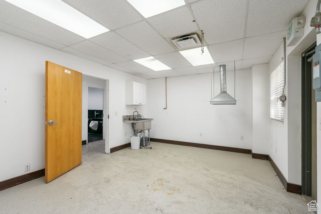 Basement with a drop ceiling and baseboards