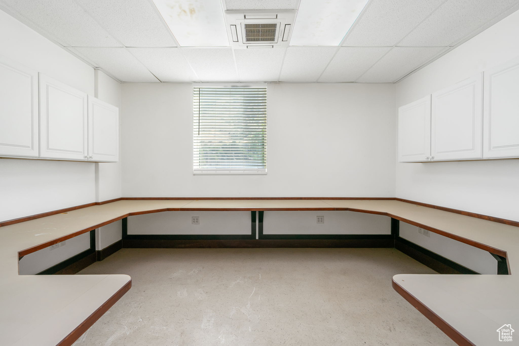 Unfurnished office with a paneled ceiling, cooling unit, and concrete floors