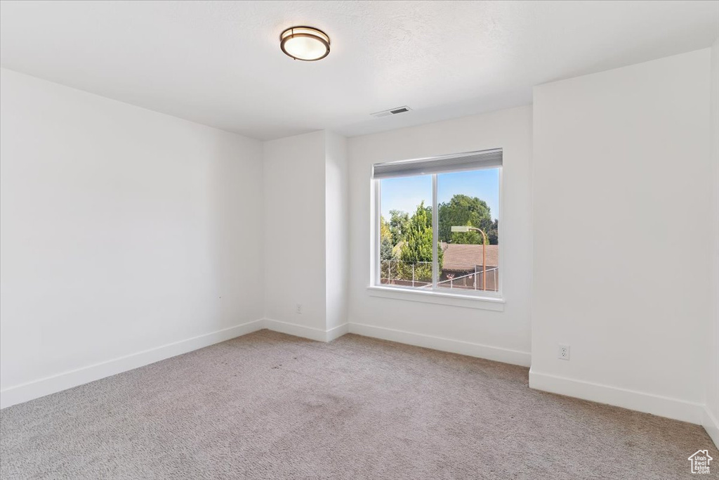 Empty room with light carpet and baseboards