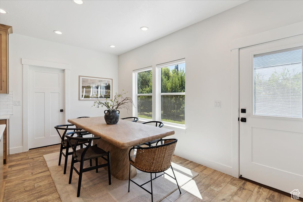 Dining room with light wood-type flooring and recessed lighting