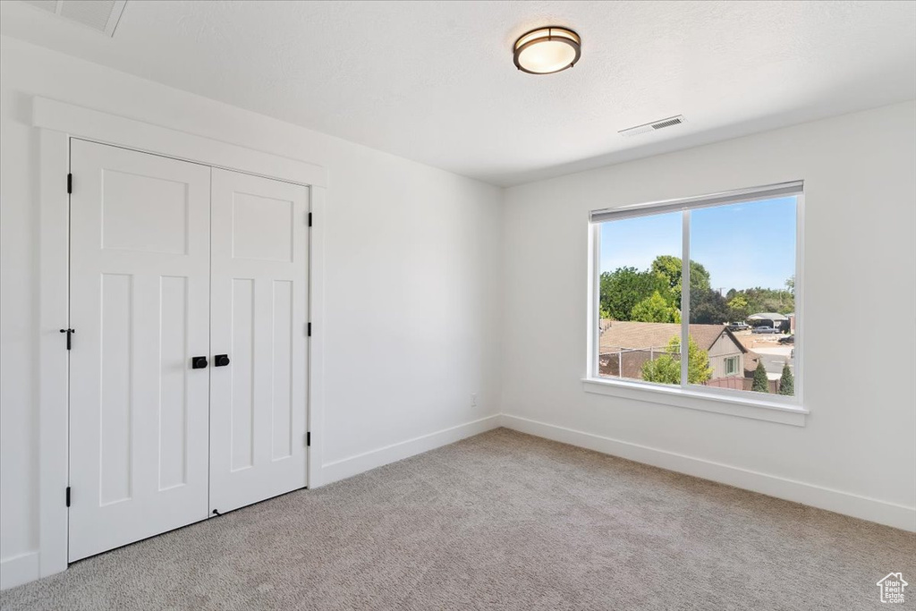 Unfurnished bedroom featuring carpet floors and a closet