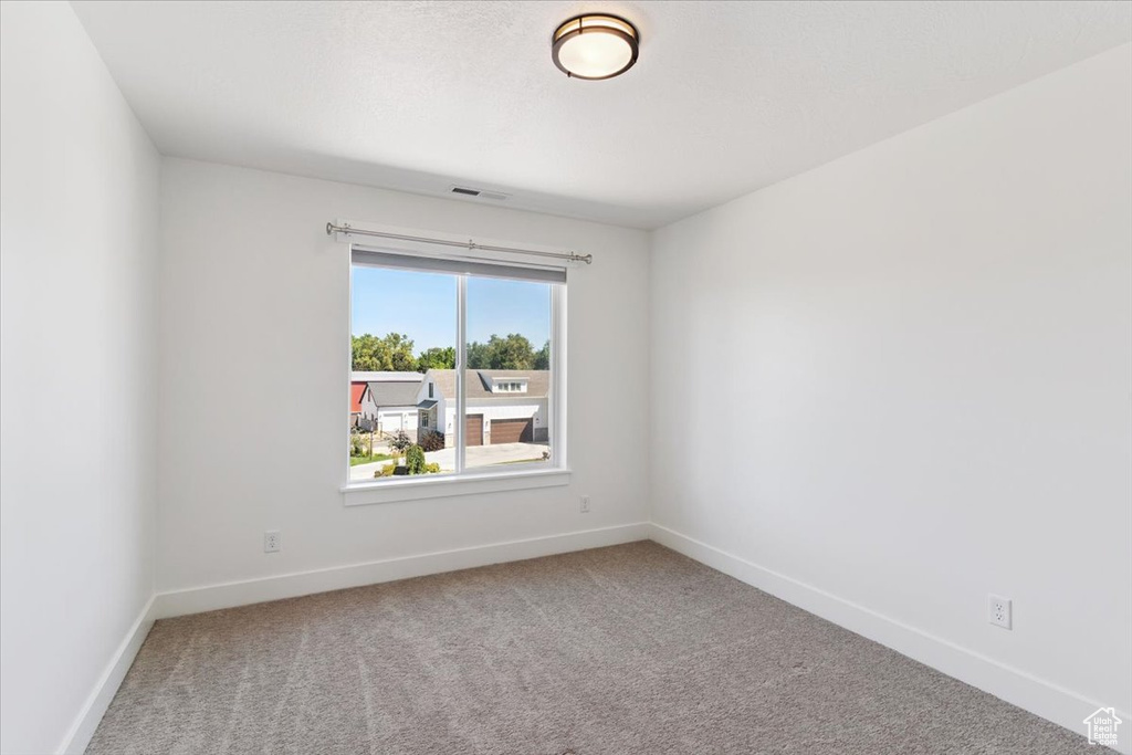 Carpeted empty room featuring baseboards