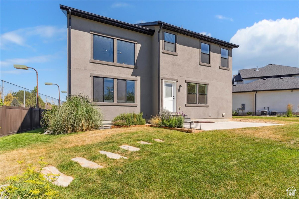 Rear view of property with stucco siding and a patio
