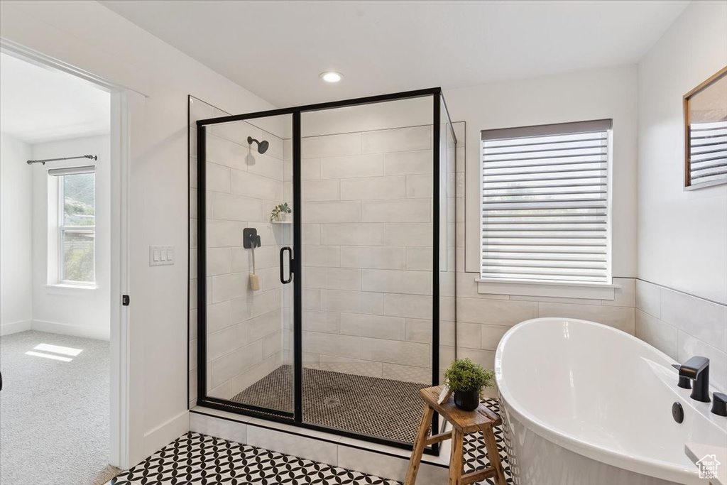 Bathroom with a soaking tub, a shower stall, and recessed lighting