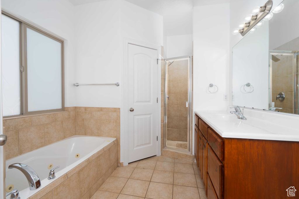 Full bath featuring a shower stall, a whirlpool tub, vanity, and tile patterned floors