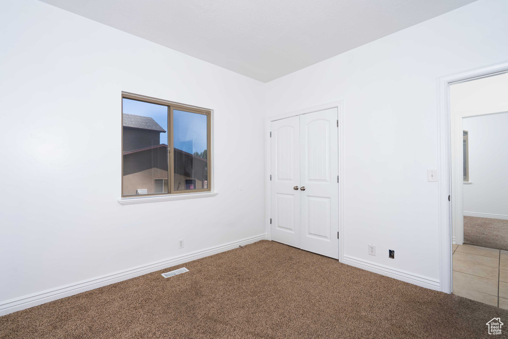 Unfurnished bedroom with carpet floors and a closet