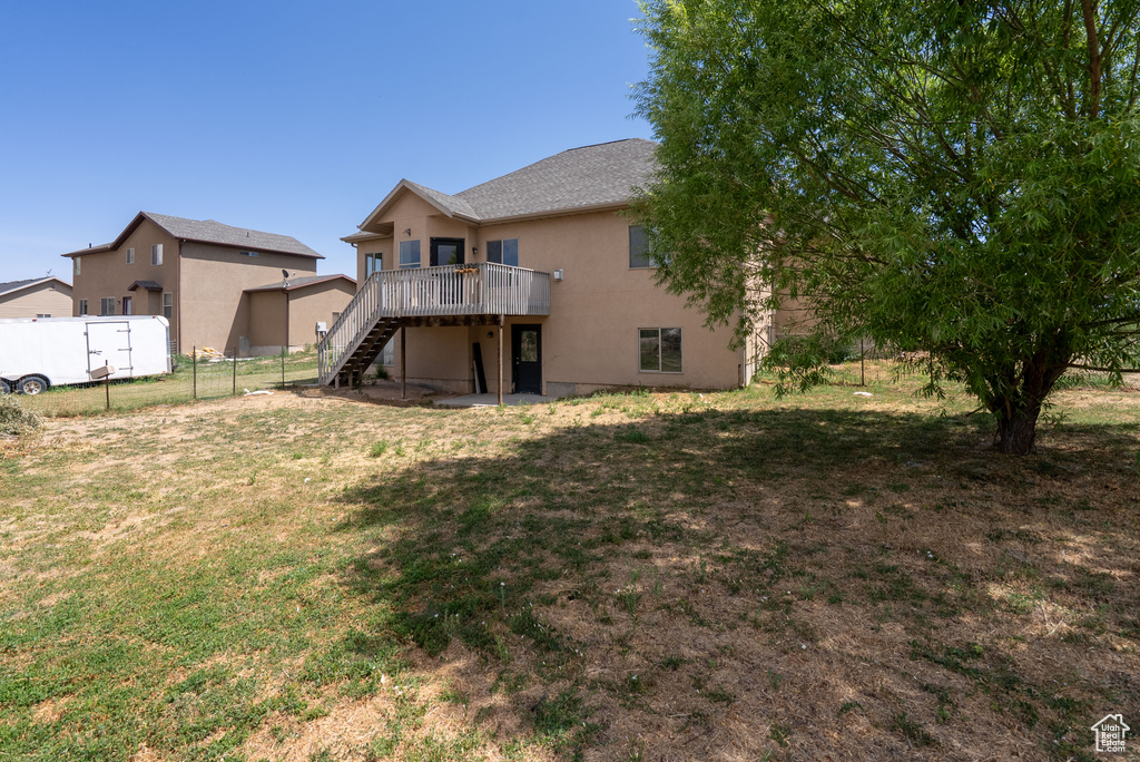 Rear view of property with stairway, a deck, and stucco siding