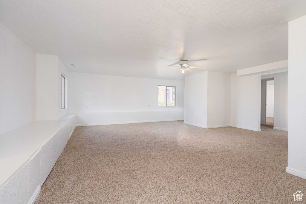 Unfurnished room with a ceiling fan and light colored carpet