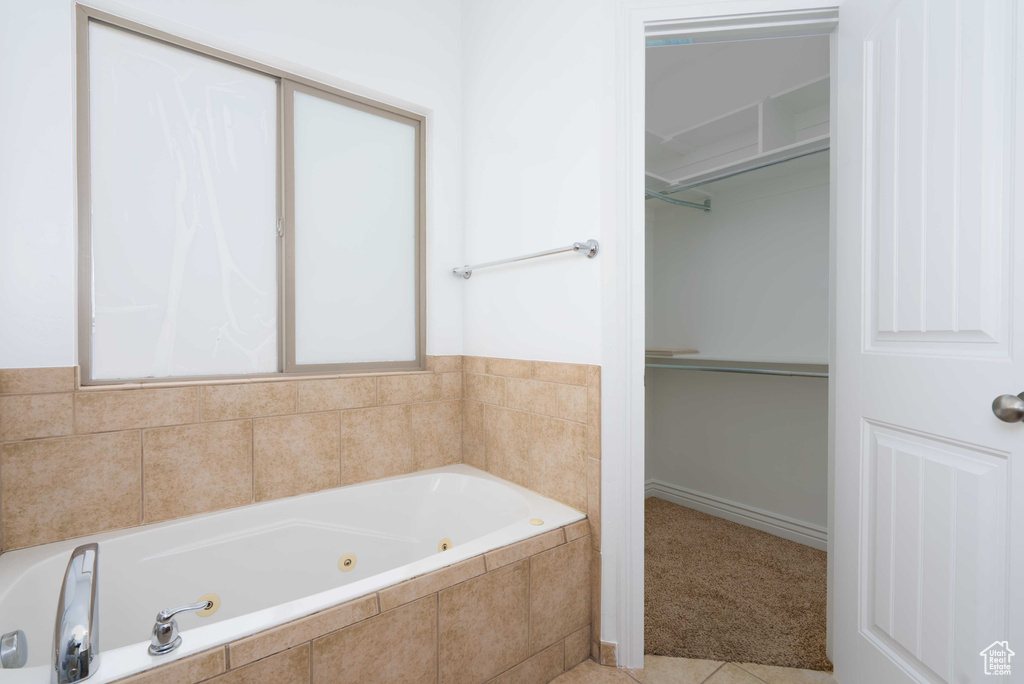 Full bath featuring a whirlpool tub and tile patterned floors