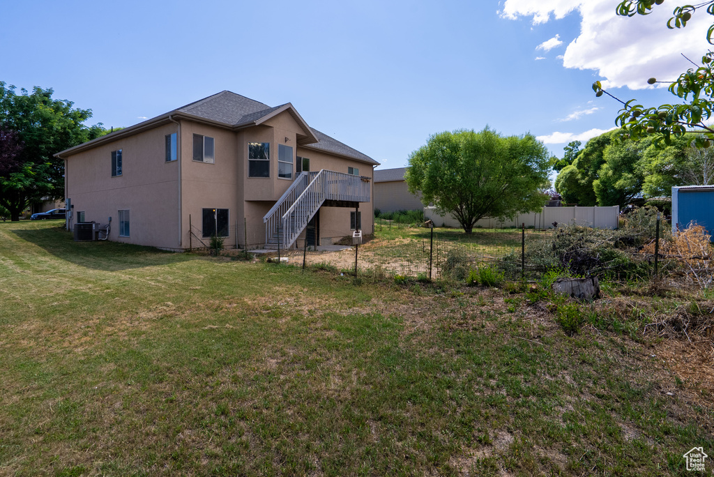 Back of house featuring stairs, stucco siding, and a wooden deck