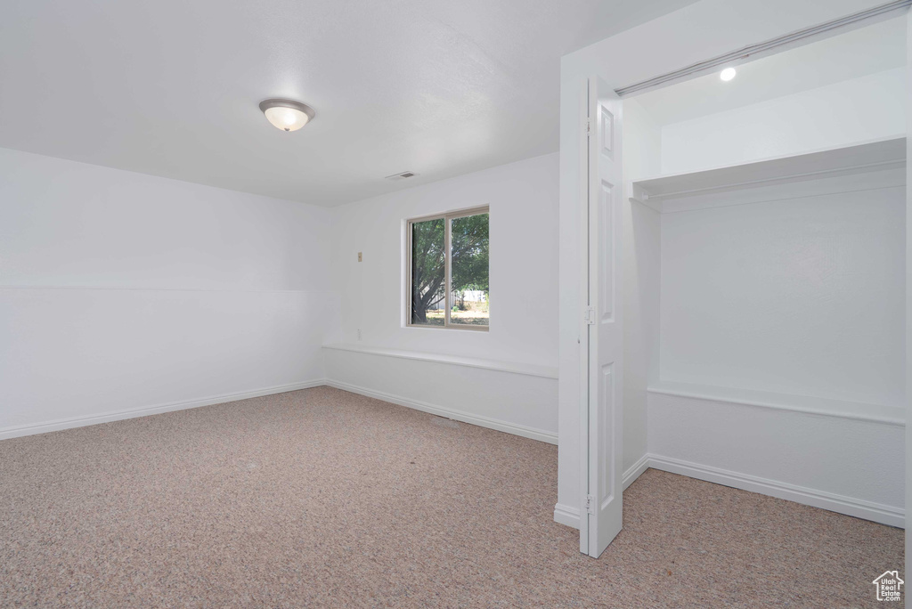 Unfurnished bedroom featuring carpet and baseboards