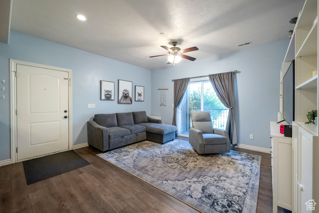 Living area featuring ceiling fan and dark wood finished floors