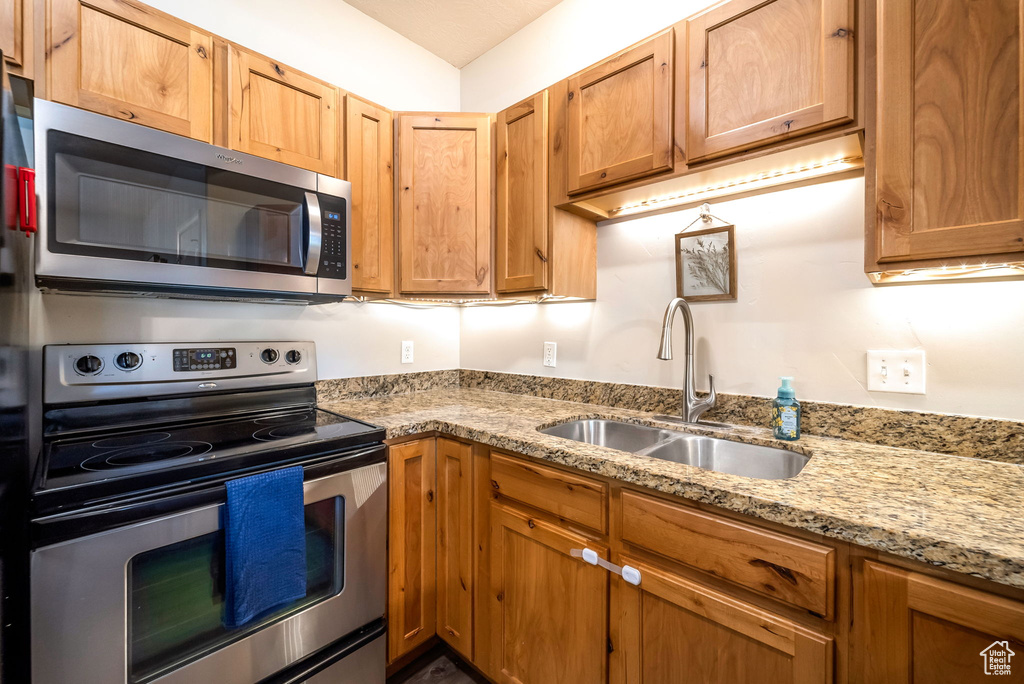 Kitchen with stainless steel appliances and light stone countertops