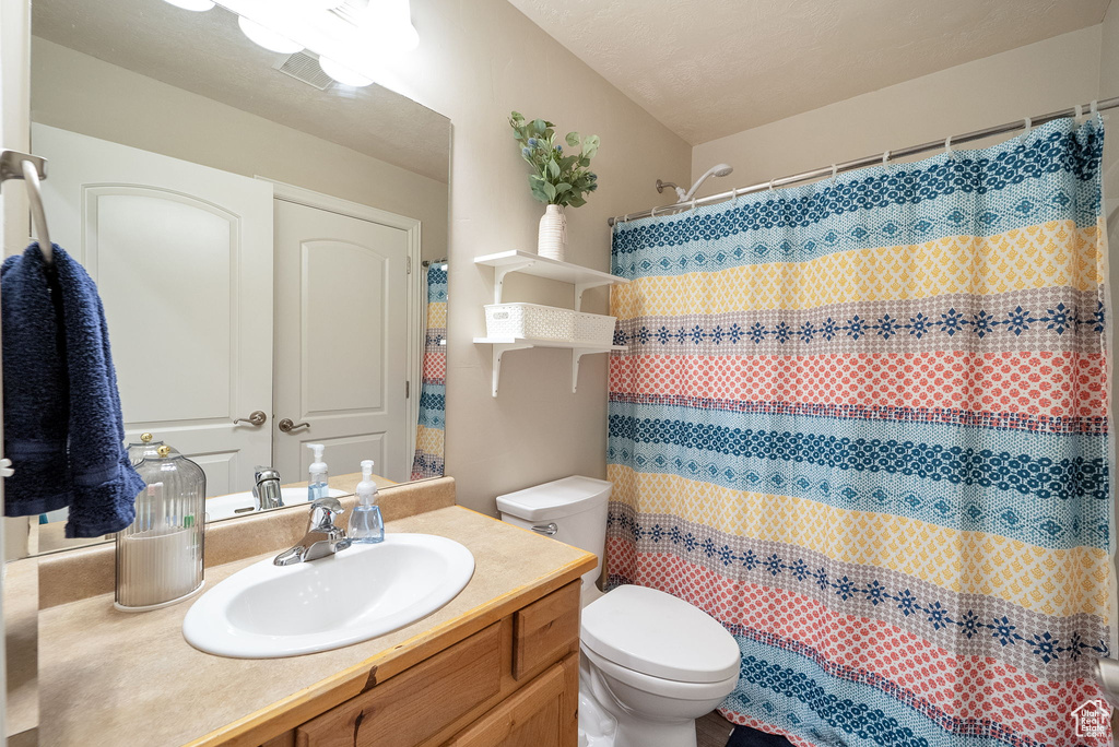 Full bath featuring vanity and curtained shower
