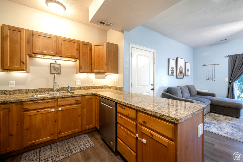 Kitchen with a peninsula, dark wood-type flooring, open floor plan, and stainless steel dishwasher