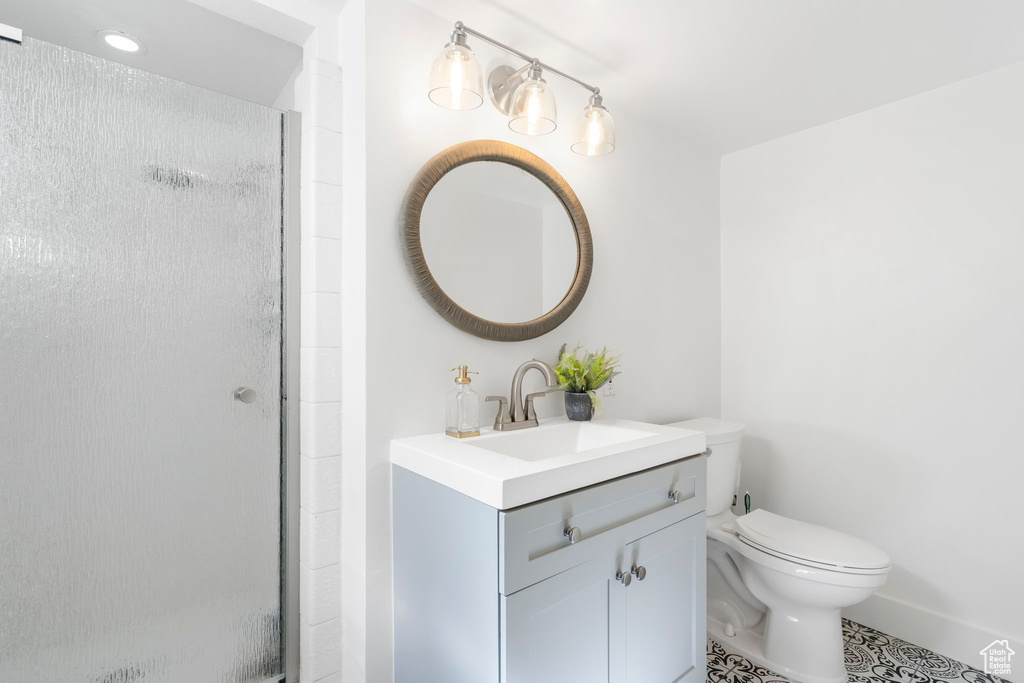 Bathroom with a stall shower, vanity, and tile patterned floors