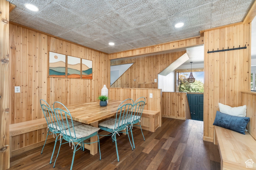 Dining space with wooden walls, an ornate ceiling, wood finished floors, and recessed lighting