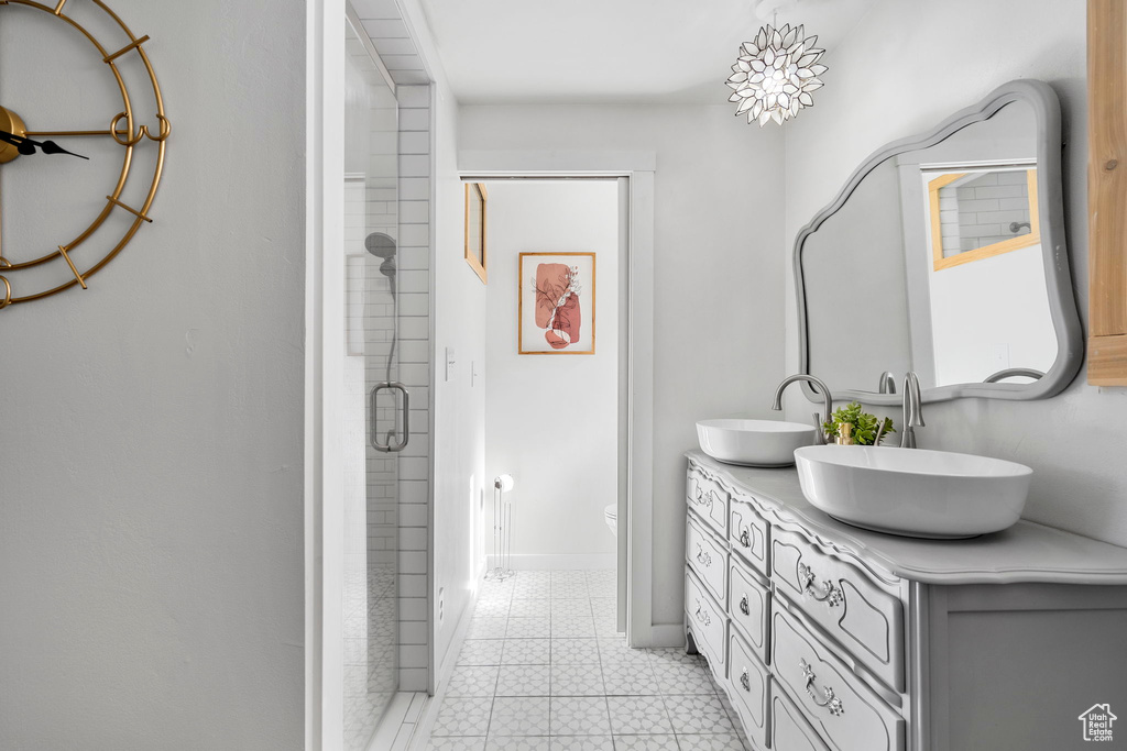 Bathroom featuring double vanity and a shower stall