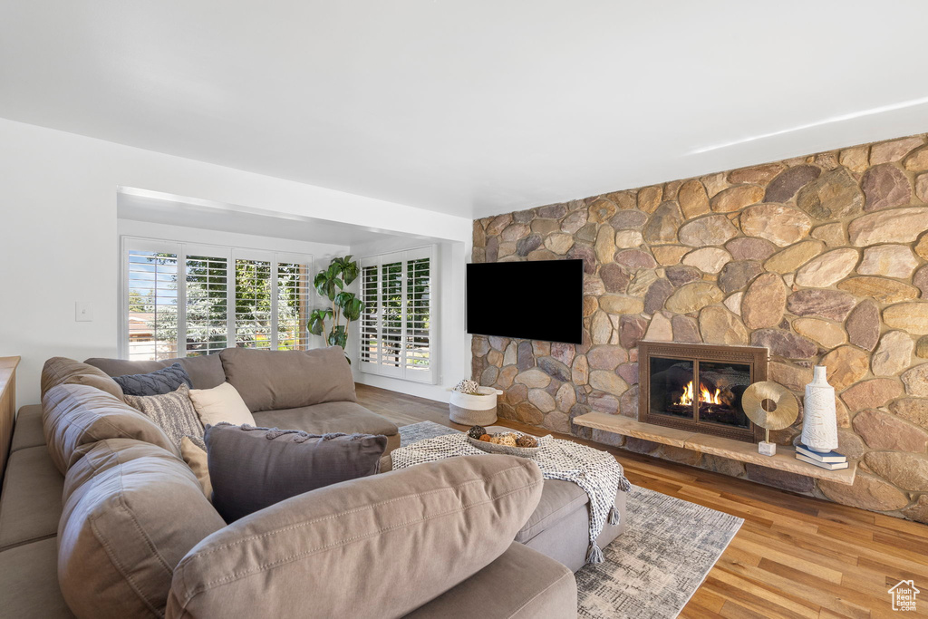 Living room with wood finished floors and a stone fireplace