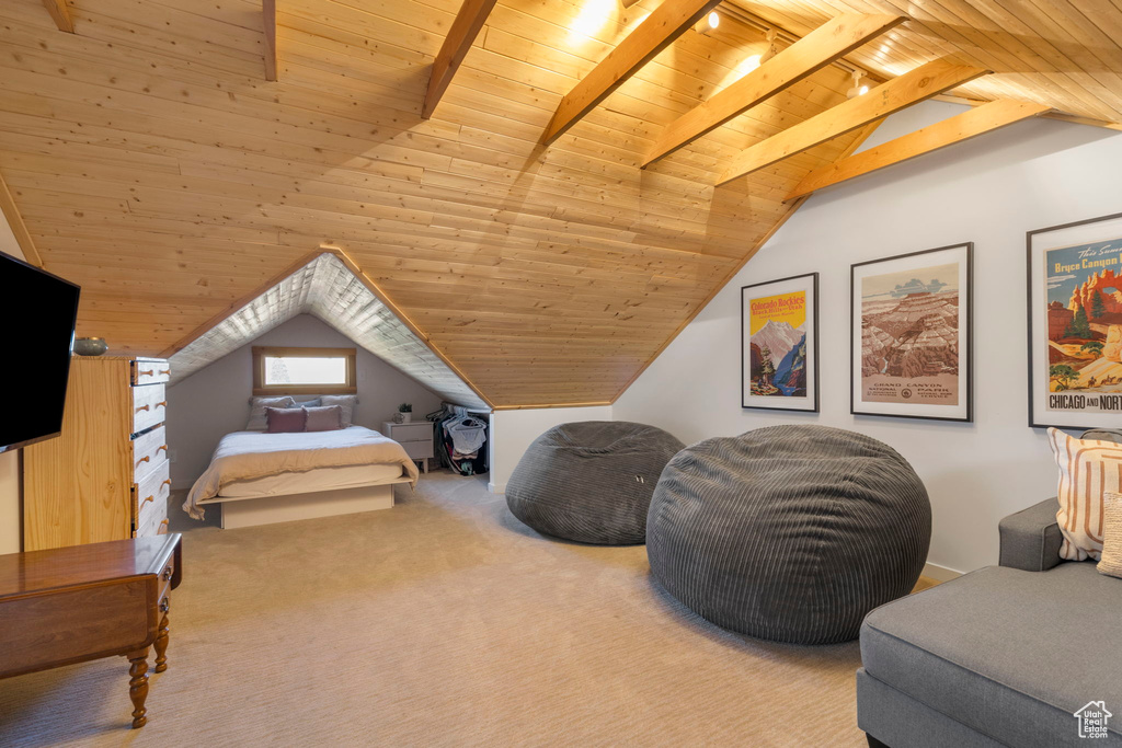 Carpeted bedroom with wood ceiling, vaulted ceiling, and rail lighting