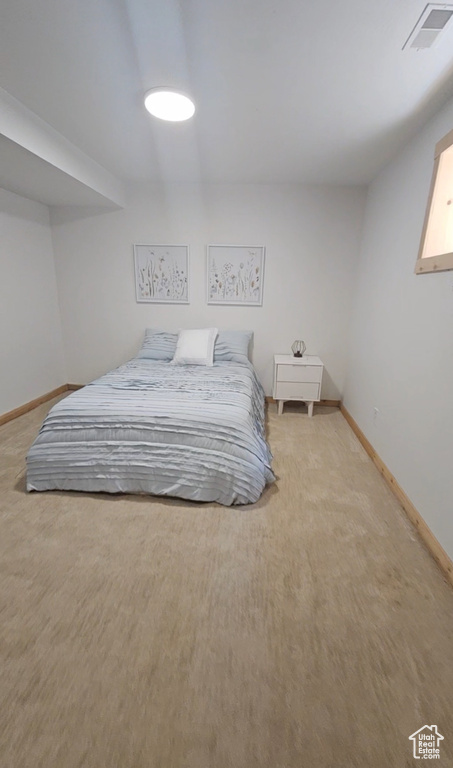 Bedroom featuring light carpet and baseboards