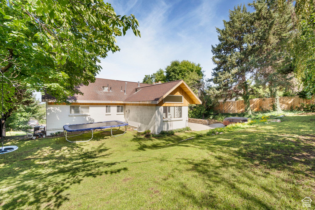 Back of house featuring a trampoline