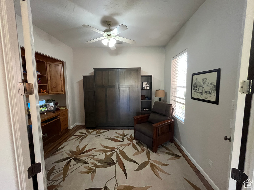 Sitting room featuring a ceiling fan and baseboards