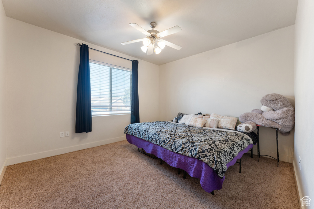 Carpeted bedroom with baseboards and a ceiling fan