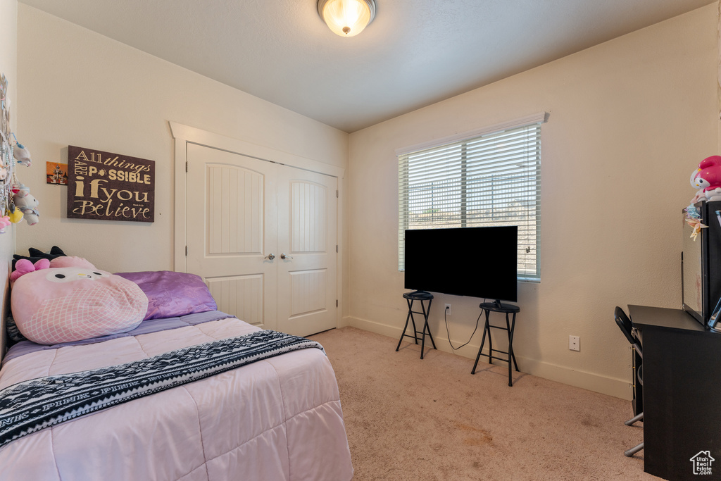 Carpeted bedroom featuring a closet and baseboards