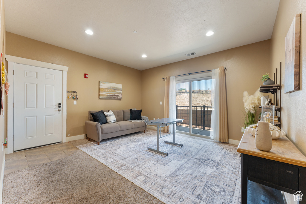 Carpeted living room with recessed lighting and baseboards