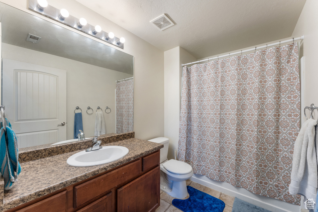 Bathroom featuring vanity, tile patterned flooring, and shower / tub combo