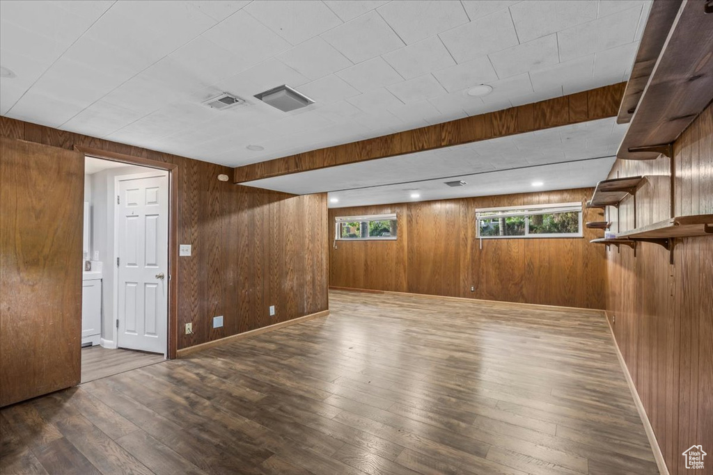 Below grade area featuring hardwood / wood-style floors and wood walls