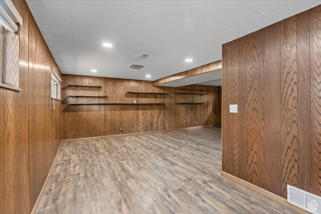 Bar featuring wooden walls, wood finished floors, and recessed lighting