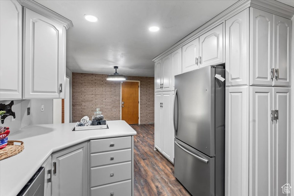 Kitchen featuring freestanding refrigerator, white cabinetry, and light countertops