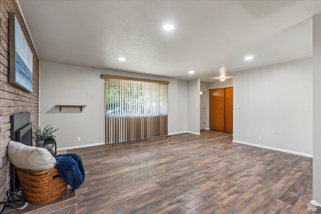 Living room featuring recessed lighting, a brick fireplace, and wood finished floors