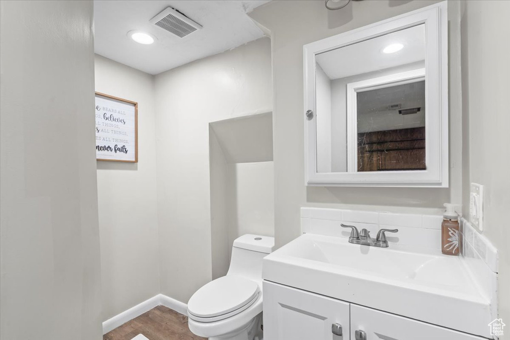 Half bathroom with vanity and wood finished floors