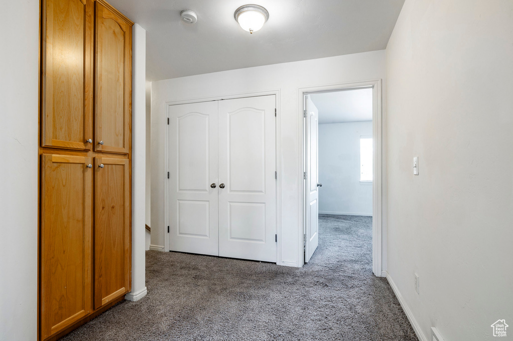 Corridor featuring carpet floors and baseboards