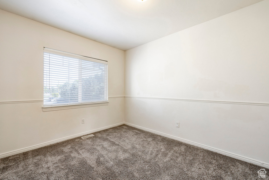 Unfurnished room featuring carpet and baseboards