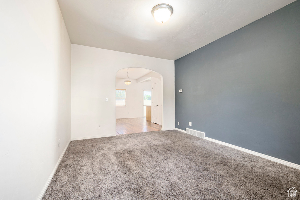 Empty room with arched walkways and carpet floors