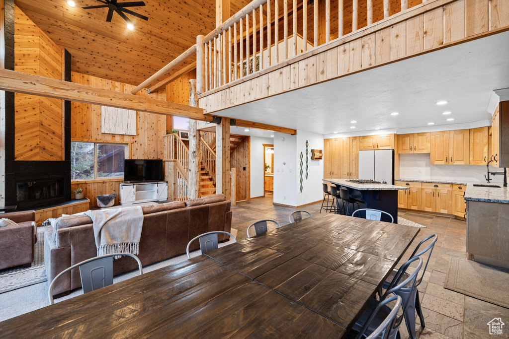 Dining area with recessed lighting, a towering ceiling, a ceiling fan, stone tile floors, and stairs