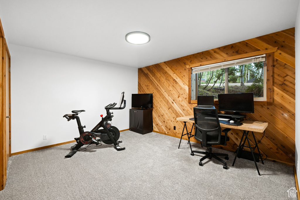 Carpeted office space with wooden walls and baseboards