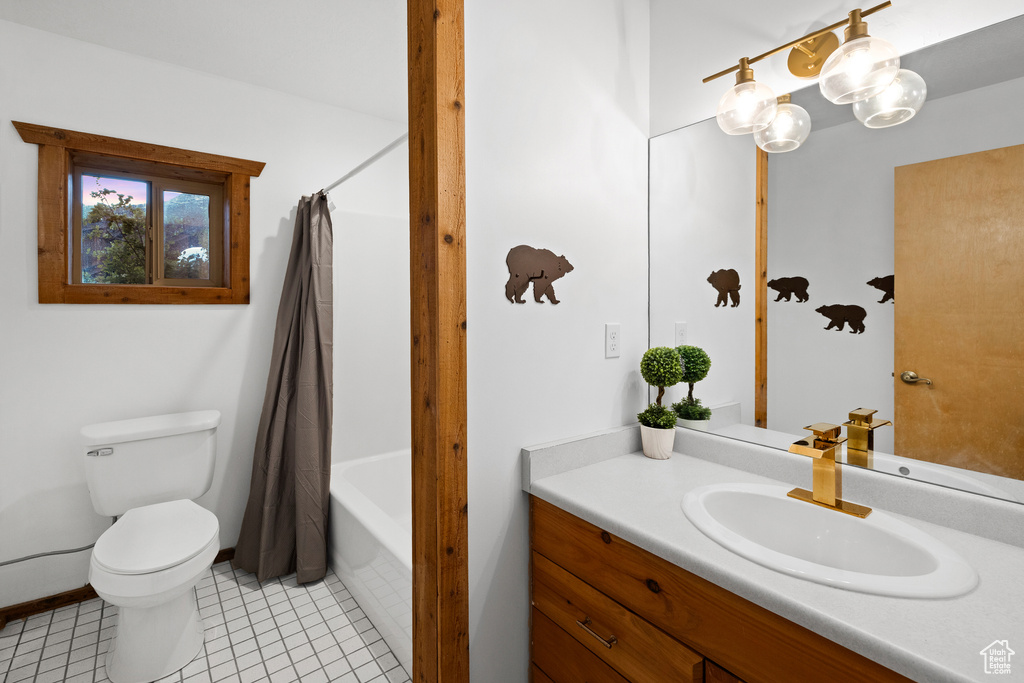 Full bath featuring vanity, tile patterned flooring, and shower / bath combo with shower curtain