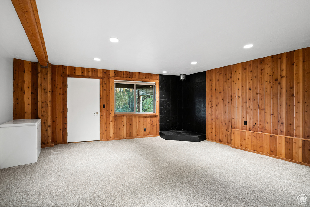 Carpeted empty room with recessed lighting and wooden walls
