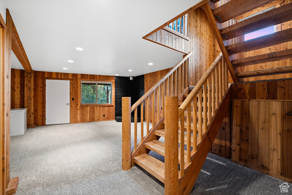 Stairway with carpet flooring, recessed lighting, and wood walls