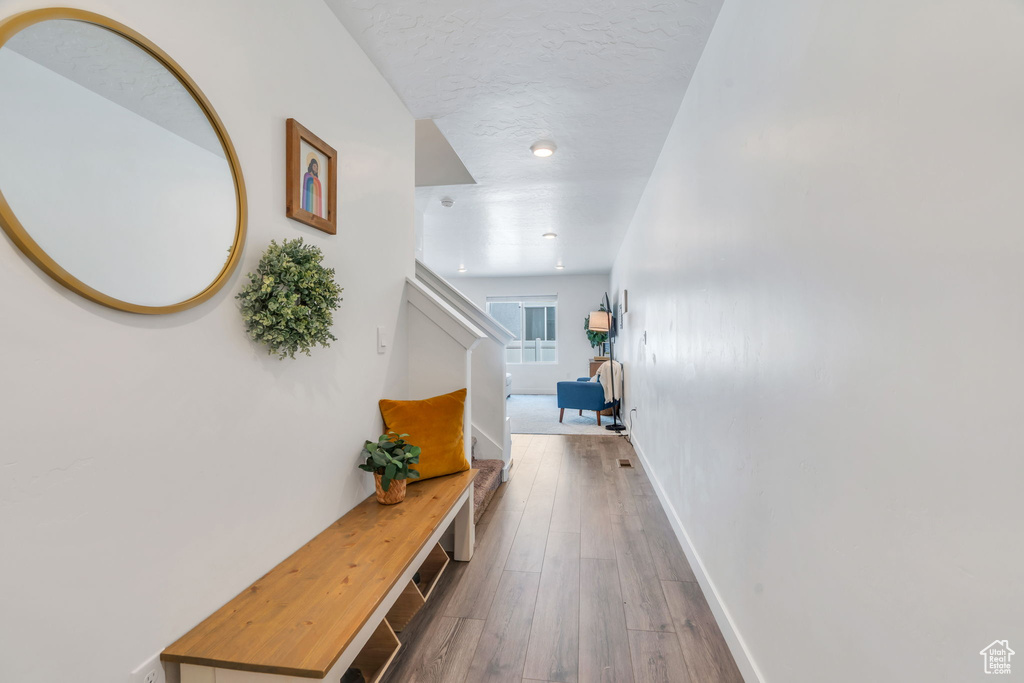 Hallway featuring wood finished floors and stairs
