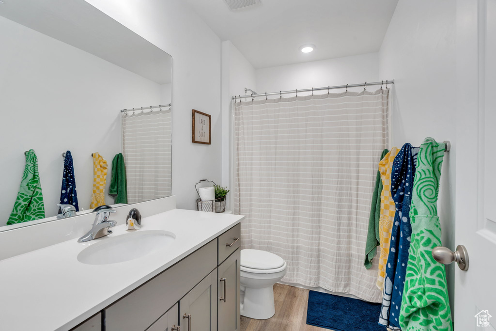 Full bathroom featuring vanity, wood finished floors, and a shower with shower curtain