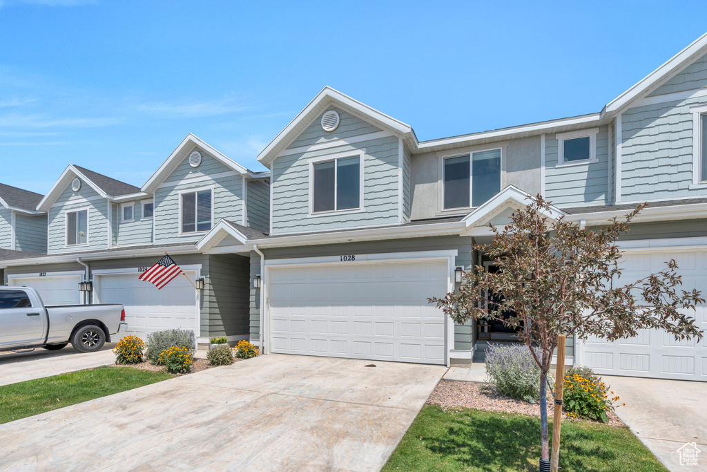 View of front of property with an attached garage and concrete driveway