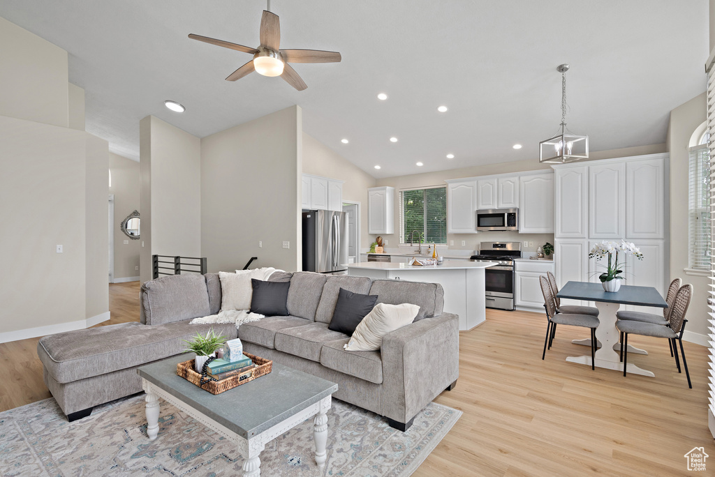 Living area featuring light wood-type flooring, recessed lighting, a ceiling fan, and high vaulted ceiling