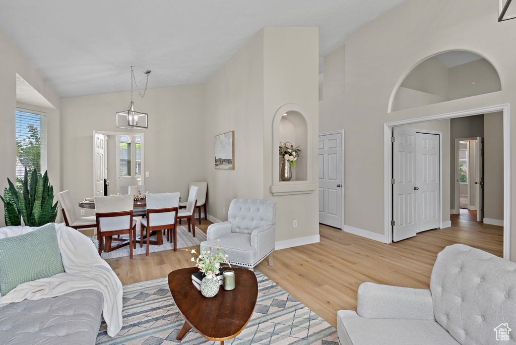 Living room featuring light wood-style flooring and high vaulted ceiling