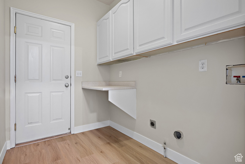 Laundry area with electric dryer hookup, light wood-style flooring, cabinet space, washer hookup, and gas dryer hookup